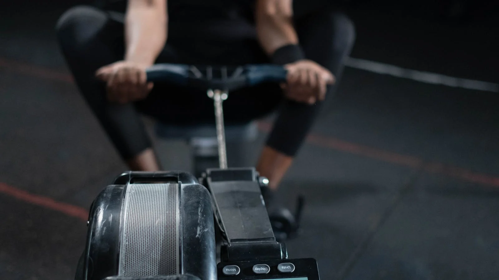 Person using a rowing machine during an indoor workout.