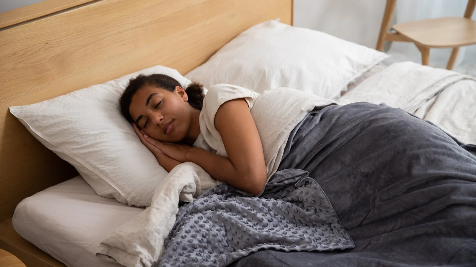 Folded weighted blanket on a calm bedroom bed.