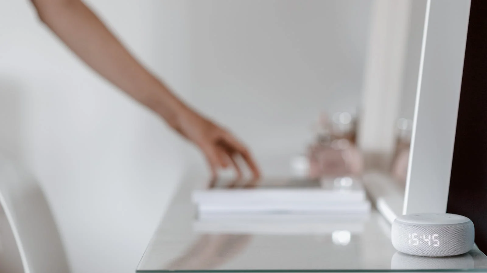Small smart speaker on a bedside table in a calm bedroom.